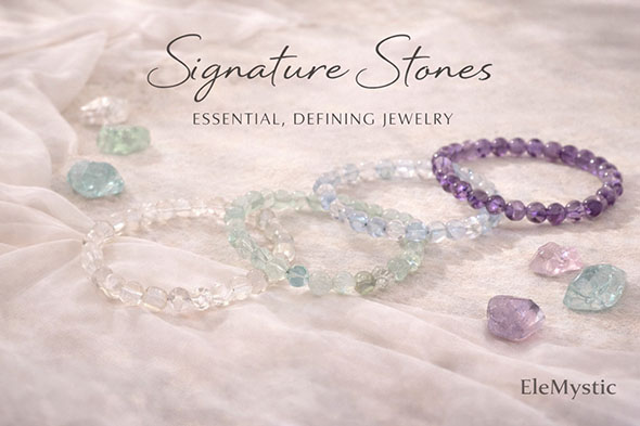 Signature Stones bracelet collection displayed on a soft fabric surface, featuring moonstone, fluorite, aquamarine, and amethyst beads in calm, refined tones.
