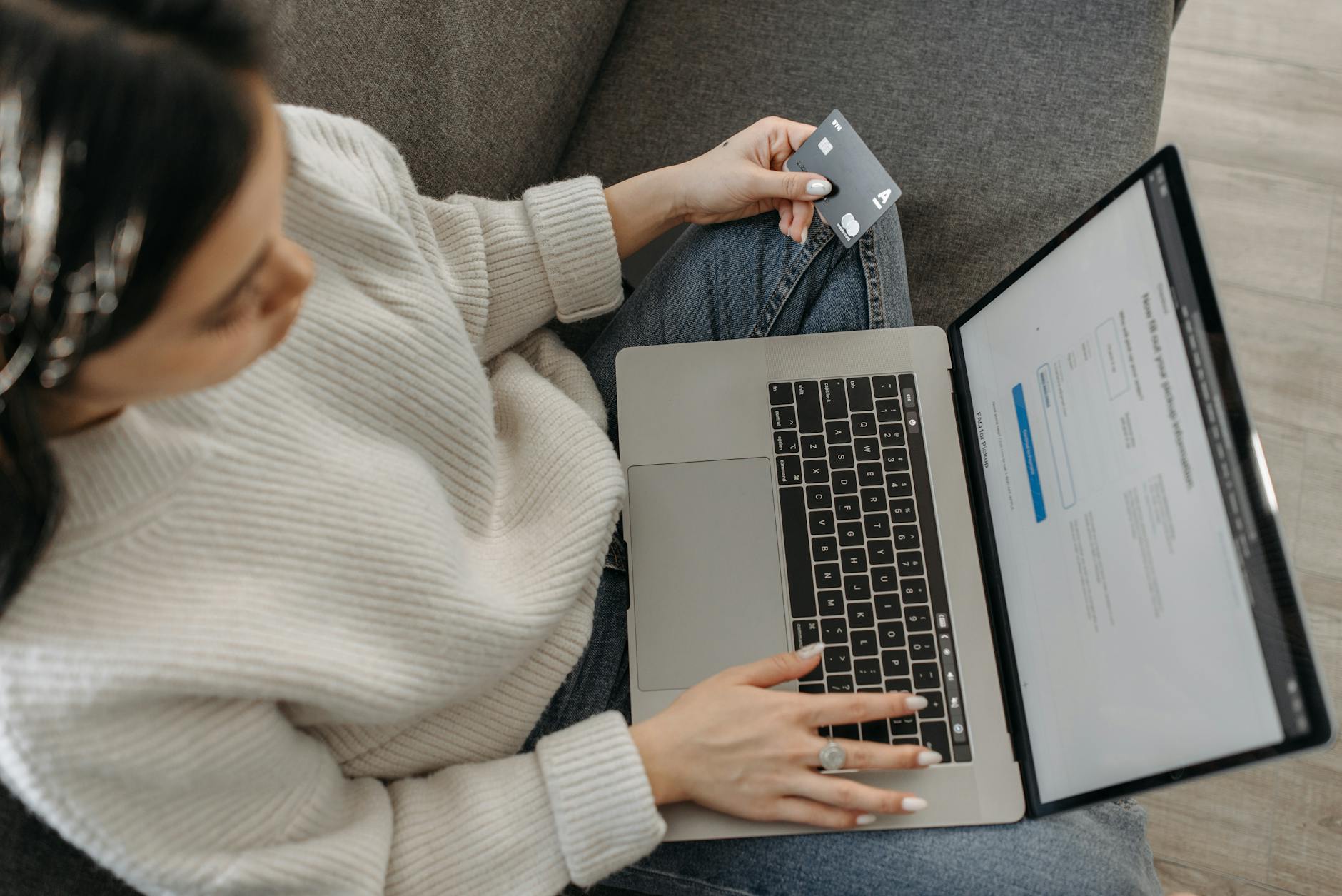 Close up of hand wearing a gold citrine ring while typing on laptop-photo-by-pexels